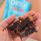 Handful of Cheeki OG biltong slices with the pack behind
